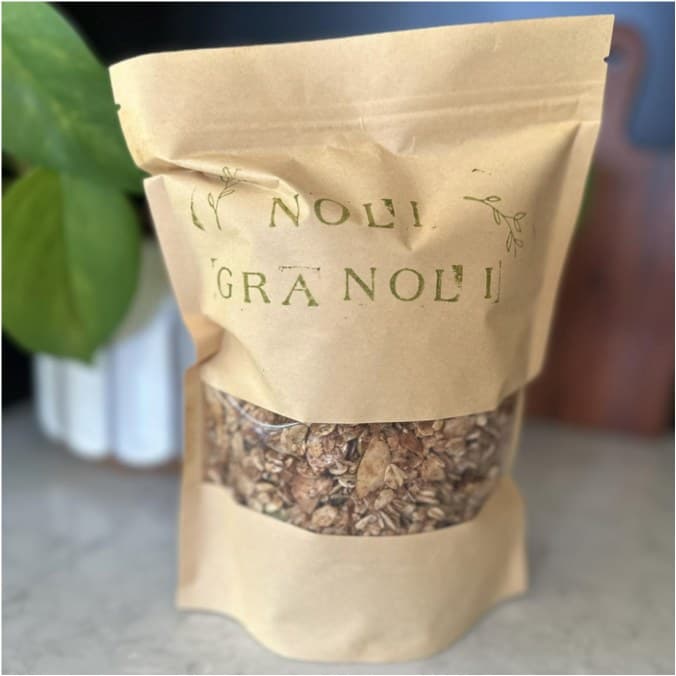 A simple paper bag of granola photographed on a kitchen counter