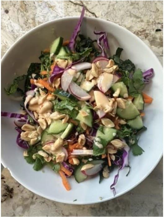 A crunchy chopped salad with cucumbers, purple cabbage, herbs, and peanuts
